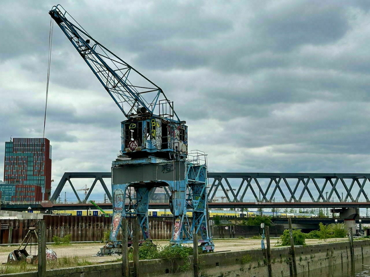An old port crane, about dilapidated and sprayed everywhere with graffiti, in Hamburg Hafen City.